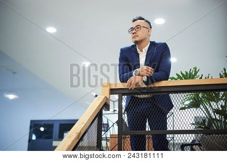 Pensive Young Vietnamese Entrerpenur In His Modern Office