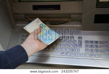 Boy Takes Money At Atm Machine In Europe