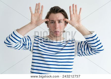 Infantile Adult Man Making Face And Gesturing Like His Hands Are Antlers. Funny Unserious Guy Grimac