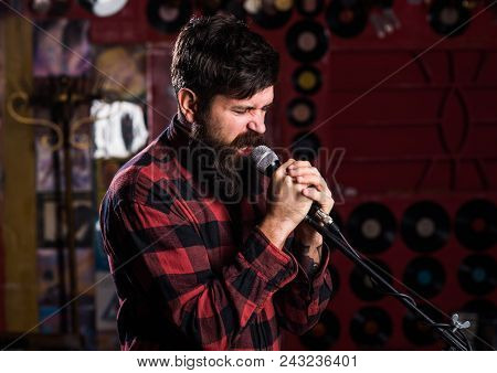 Musician With Beard And Mustache Singing Song In Karaoke. Man With Enthusiastic Face Holds Microphon