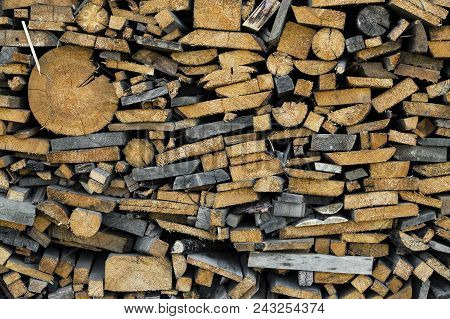 Wood Chopped Firewood Stacked On The Stack. Background Of Firewood Stack. Stack Of Chopped Firewood 