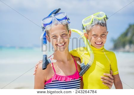 Brother And Sister Playing And Having Fun On The Beach During The Hot Summer Vacation Day.