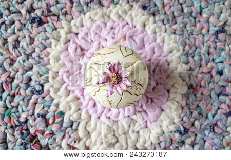 One Lilac Flower Xeranthemum On Round Clay Vase On Knitted Patchwork Background Texture Background. 