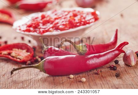 Red Hot Chilli Sauce On A Wooden Table