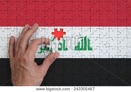 Iraq Flag  Is Depicted On A Puzzle, Which The Man's Hand Completes To Fold