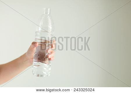 A Hand Is Holding Of Drinking Water Bottle On White Background.