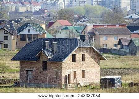 Brand New Spacious Brick Two Story Residential House With Tiling Roof And Windows Openings In Suburb