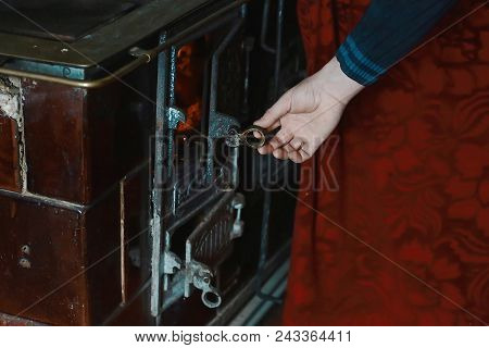 Open Firebox With Burning Firewood, Man's Hand Opens Vintage Metal Door Furnace