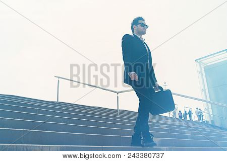 Young Confidental Businessman Wearing Suit And Running Fast Downstairs. Horizontal Outdoors Shot.