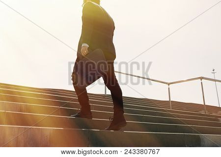 Young Confidental Businessman Wearing Suit And Running Fast Upstairs. Horizontal Outdoors Shot.sunny