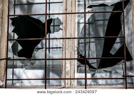 Smashed Glass Window With Old Wooden Frame On Grunge Wall Damaged House