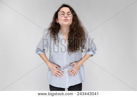 Young Girl With Glasses On A Gray Background. Portrait Of A Young Beautiful Girl. A Charming Girl In