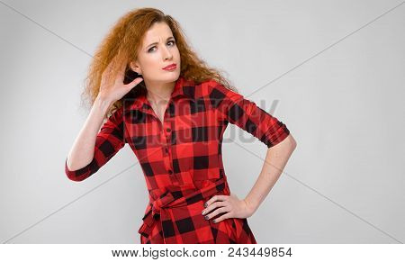 Charming Young Girl In A Checkered Cloth On A Gray Background