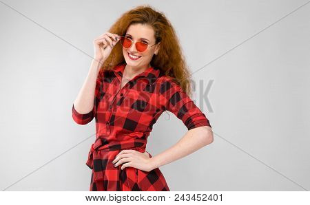 Charming Young Girl In A Checkered Cloth On A Gray Background