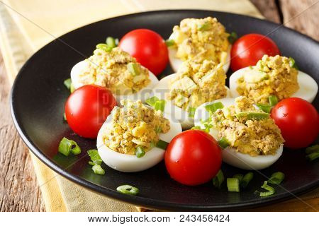 Homemade Chicken Eggs Stuffed With Canned Tuna And Avocado With Tomatoes And Green Onions Close-up.