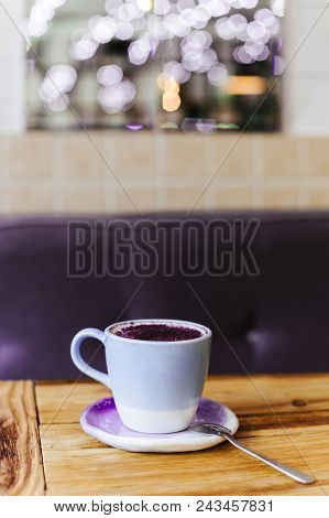 Lavender Latte In A Violet Cup On A Wooden Table On A Beautiful Blurred Background. Lavender Latte I