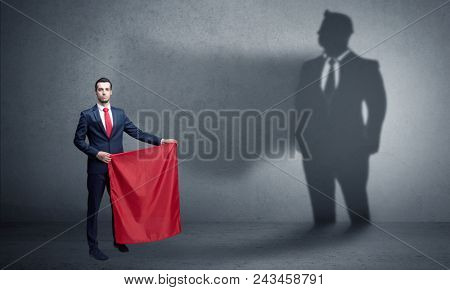 Businessman standing with red cloth on his hand and his shadow on the background
