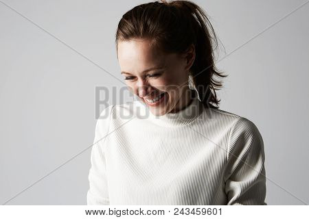 Fashion Photo Of A Beautiful Smiling Brunette Woman In A White Roll-neck Sweater Posing Over Gray Em
