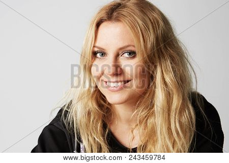 Close Up Shot Of Stylish Young Woman Smiling Against Gray Background. Beautiful Female Model With Co