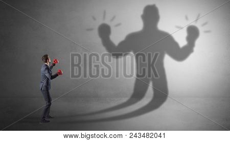 Businessman trying to fight with his unarmed shadow