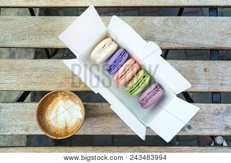 Different French Macaroon Cake In Pastel Colors With A Cup Of Coffee. Five Macaroons In White Box On