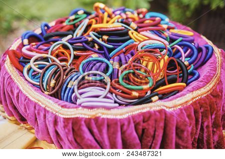The Colorful Of Bangles Or Embraces On The Pink Cover Tray For Guest During Mehndi (henna) Ceremony 