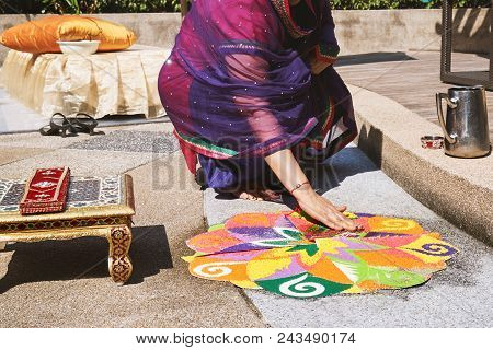 Women Decorating And Coloring Tradition Colorful Rice Art Or Sand Art (rangoli) On The Floor With Pa