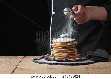 Serving Pancakes With Powdered Sugar And Berries. Chef Woman Hand. Beautiful Food Still Life. Slight