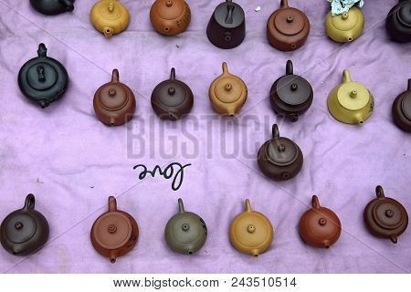 Various Chinese Clayware Tea Pots In The Violet Background.