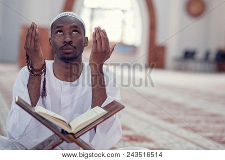 African Muslim Man Making Traditional Prayer To God While Wearing Dishdasha.