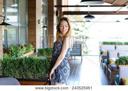 Girl Standing At Cafe Near Green Palnts. Concept Of Resting At Break Time And Youth.