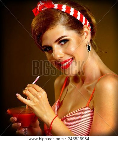 Pin up girl drink bloody Mary cocktail. Pin-up retro female style. Girl wearing red dress seduces men. Incendiary dance party. Girl performs at show in front of audience. Woman is interesting