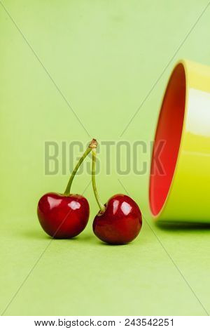 Fresh Cherries With Cup On Green Background