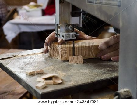 Woodworker Using The Bandsaw On Piece Of Wood