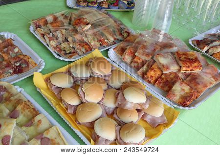 Many Trays With Foods Like Pizza And Milk Rolls With Salami Called Mortadella In Italy