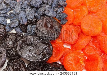 Top View Of Dark-colored Raisins, Dried Plums And Dried Apricots Closeup At Selective Focus