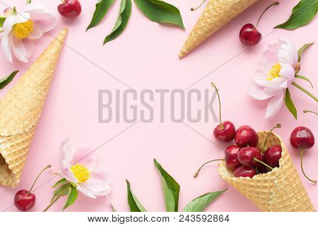 Spring Or Summer Mood Concept. Flatlay Of Cerry, Sweet Cones And Peonies Over Pastel Pink Background