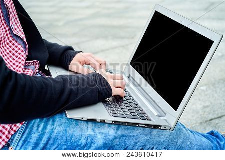 Side View Of Man In Shirt And Jeans Typing On Laptop Computer Keyboard On Khees Outdoors, Copy Space