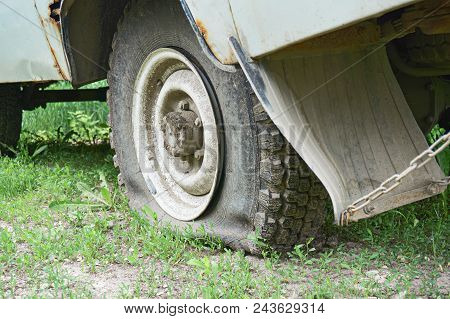 Flat Tire On An Old Rusty Suv Close-up. Abstract Background.
