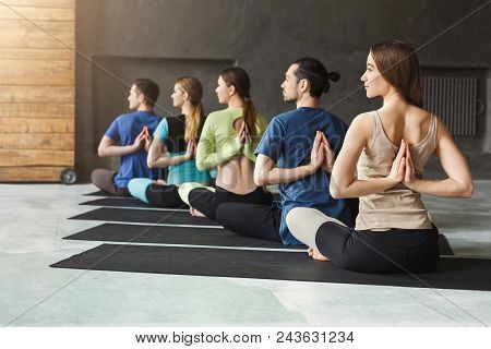 Young Women And Men In Yoga Class, Meditation Exercises. Reverse Prayer Pose, Back And Shoulders Str