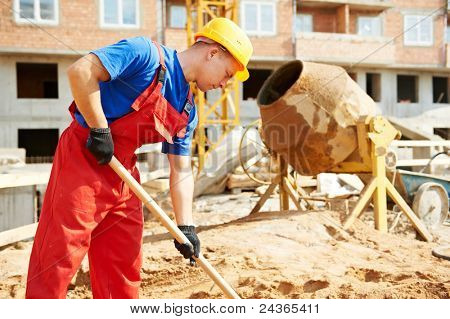 builder man working with shovel during concrete cement solution mortar preparation at construction site