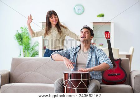 Young family singing and playing music at home