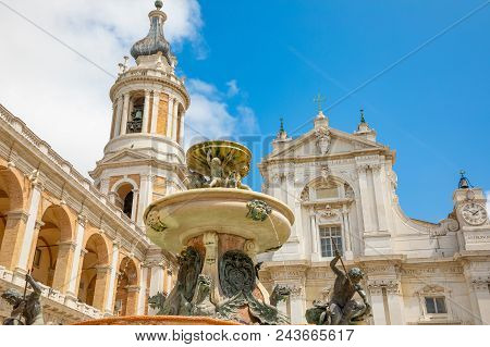 Loreto Basilica In Sunny Day, Fountain And Tower In Loreto, Italy