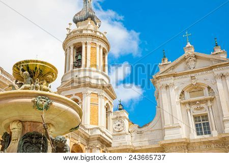 Loreto Basilica In Sunny Day, Fountain And Tower In Loreto, Italy