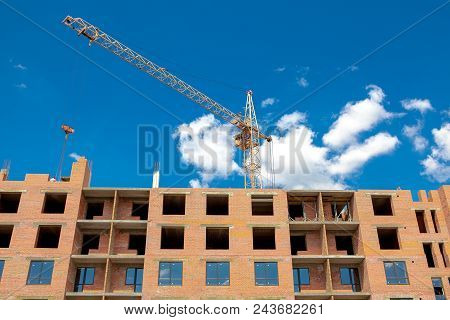 Construction Crane Over A Building Under Construction. Construction Site Background.