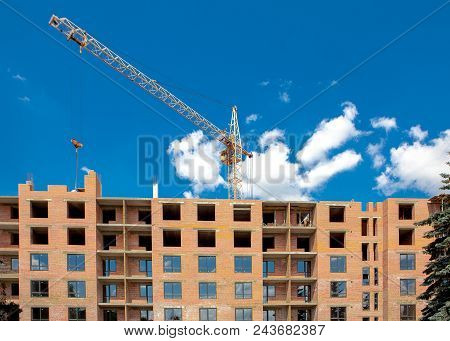 Construction Crane Over A Building Under Construction. Construction Site Background.