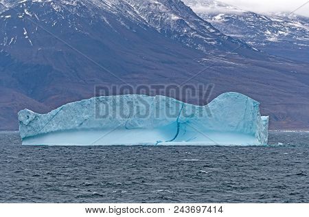 Blue Iceberg Along A Remote Coast Of Greenland Along The Nugssuaq Peninsula