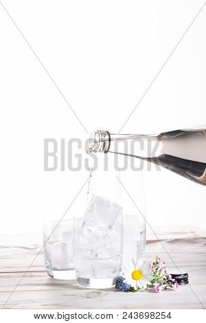 Pouring Of Stil Mineral Drink Water In Glasses With Ice Cubes Close Up Copy Space