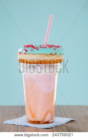Pink And Donuts Extreme Milkshakein A Plastic Cup On Blue Background. Crazy Freakshake Or Overshake 