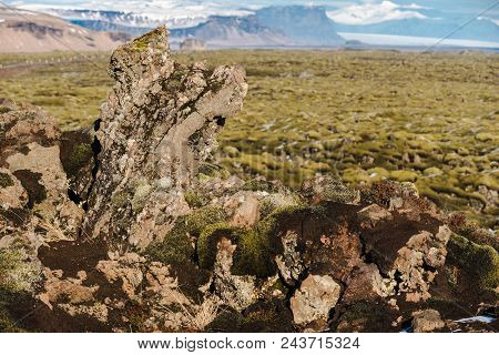 Moss-covered Rock Outcroppings In The Eldrhaun Lava Fields Of Iceland With Mountains And Glaciers In